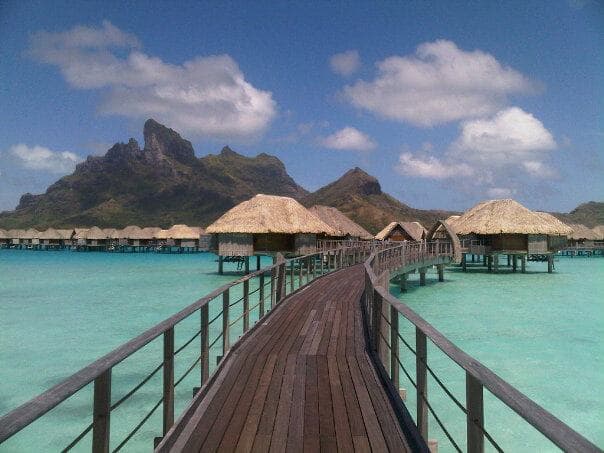 Overwater bungalows at a Bora Bora resort with Mount Otemanu behind