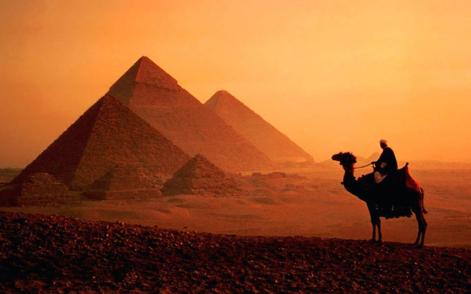 The sun setting behind the Pyramids of Giza near Cairo