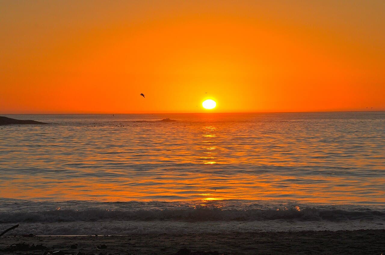 Camps Bay beach at sunset with the Twelve Apostles mountain range behind it