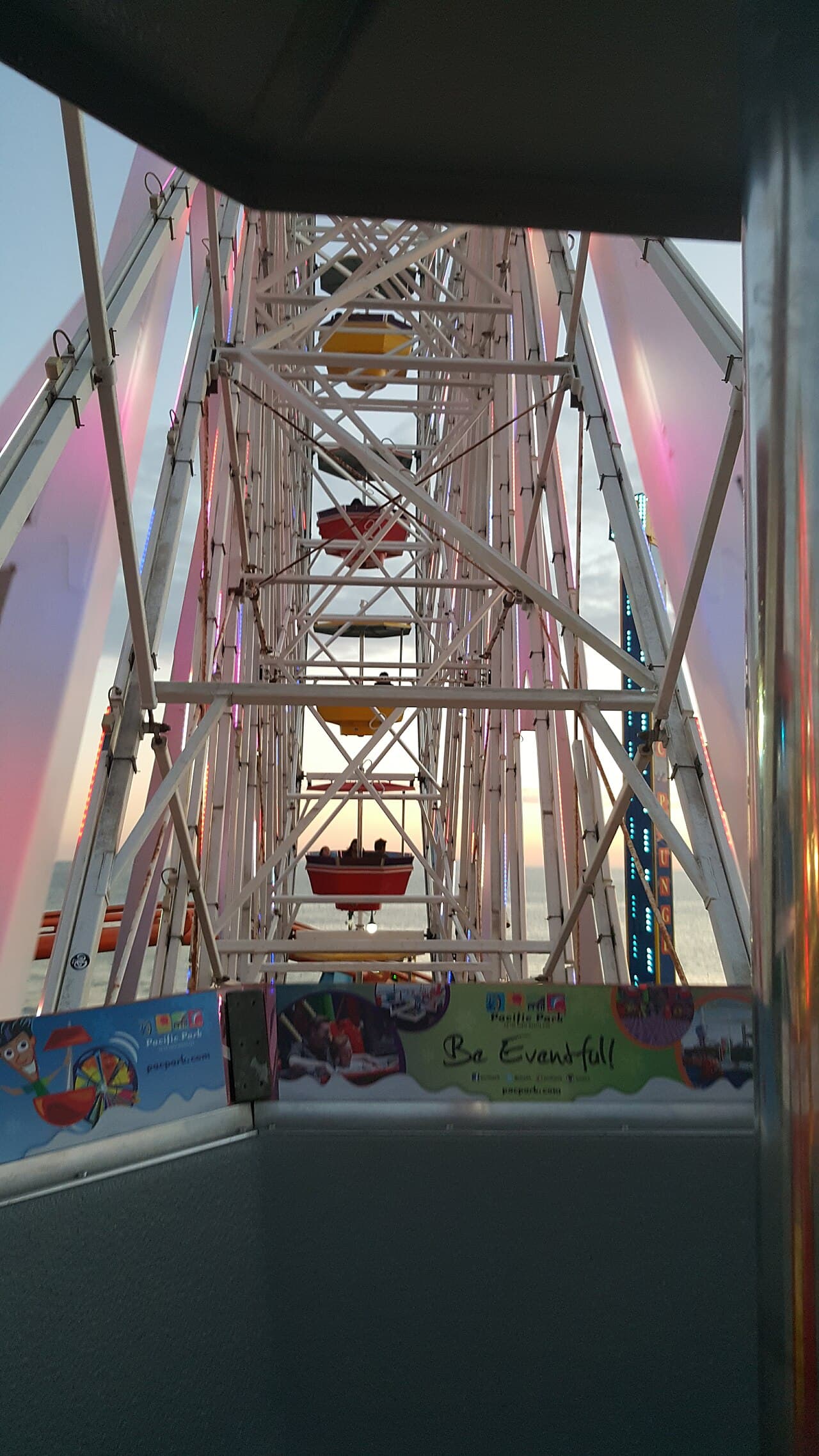 The Santa Monica Pier Ferris wheel lit up at sunset